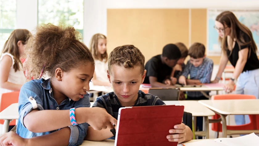 Schulkinder nutzen ein Tablet