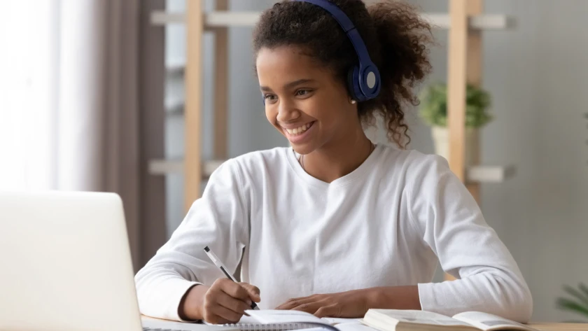 Mädchen arbeitet am Laptop mit Kopfhörern