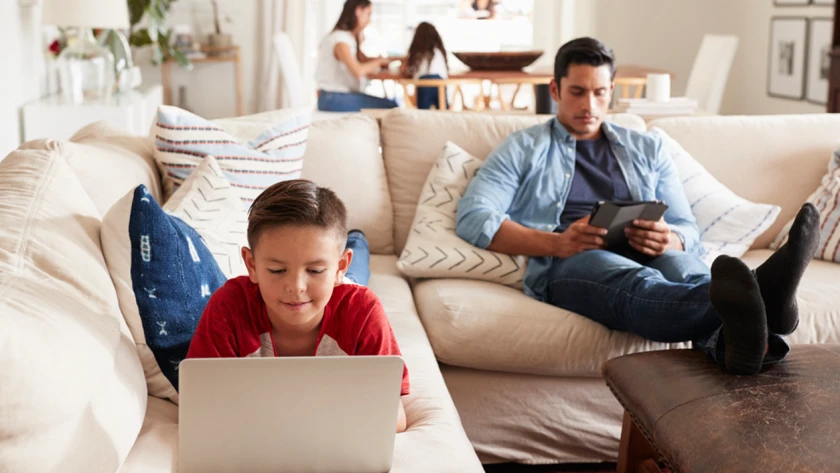 Schüler mit Laptop auf Sofa