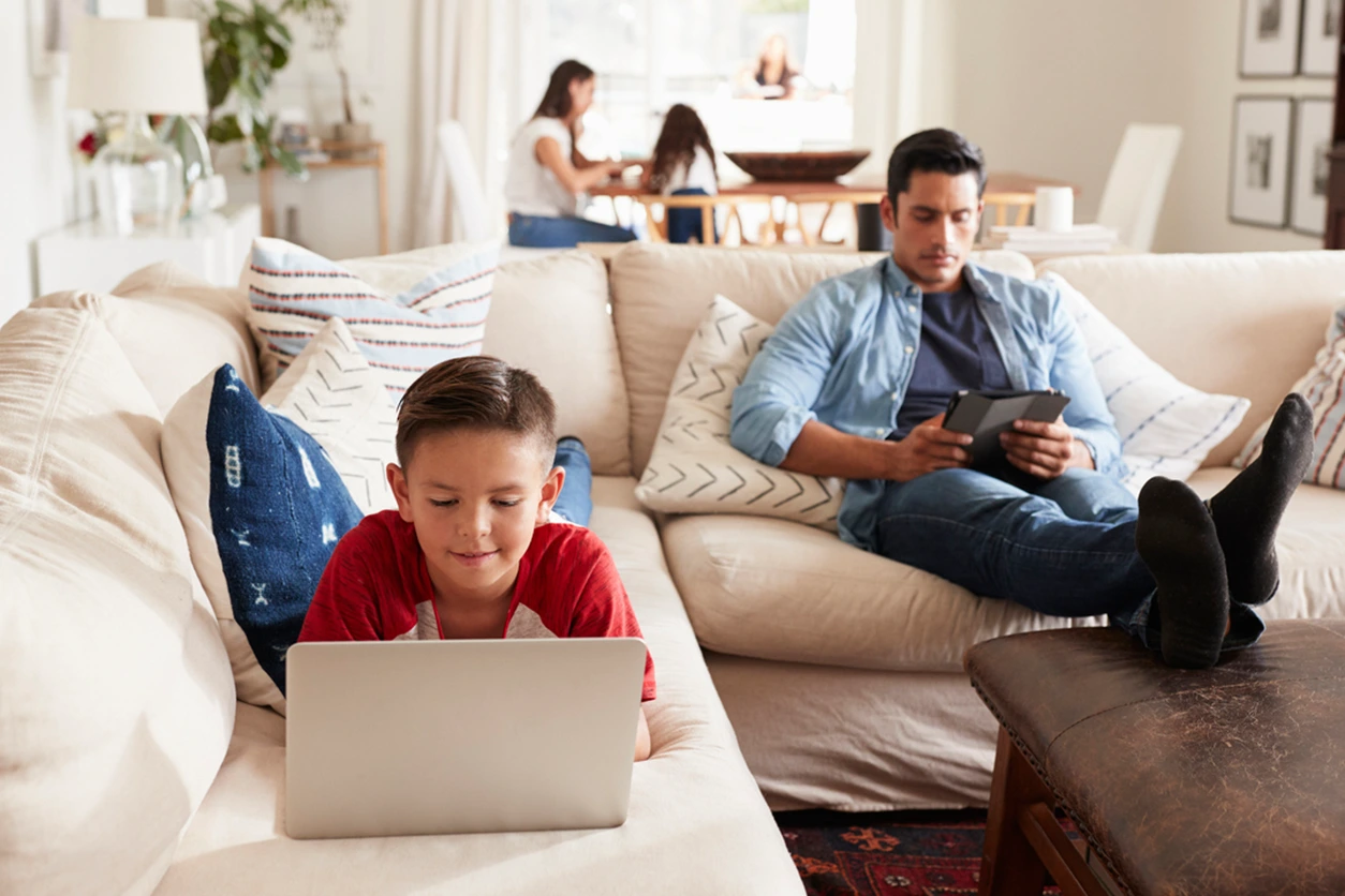 Schüler mit Laptop auf Sofa