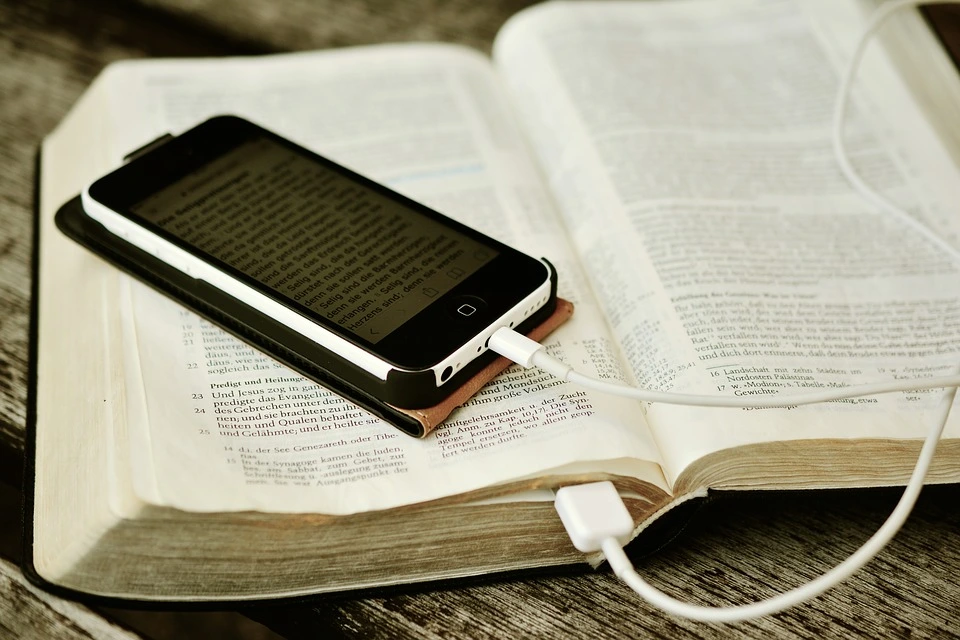 iPhone, das an einer Bibel angesteckt ist