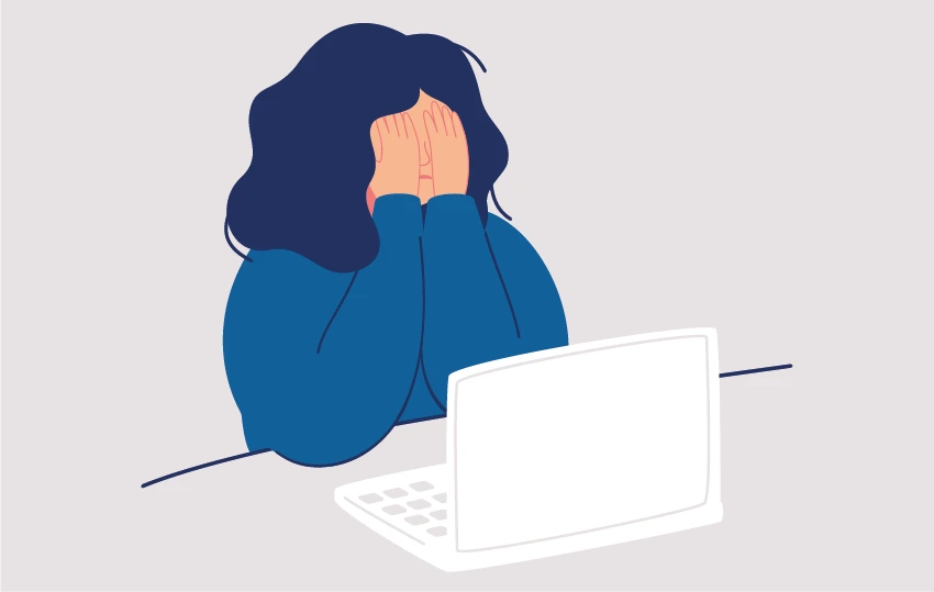 Mädchen sitzt vor einem Laptop und schlägt die Hände vors Gesicht