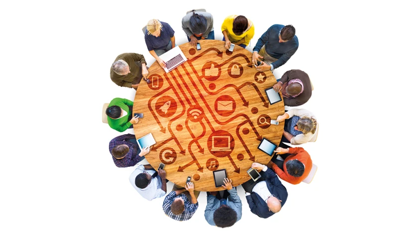 Runder Tisch mit Multi-ethnischen Menschen, die digitale Services nutzen