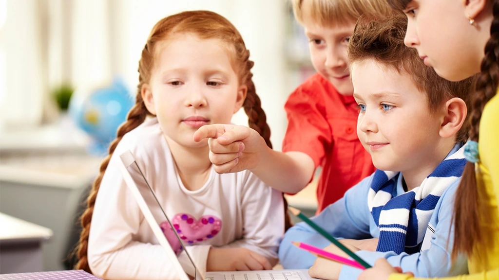 Gruppe von 4 Kindern vor einem Laptop